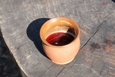 High angle view of bitter ale in container on wooden table