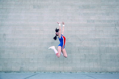 Woman with umbrella while walking on wall