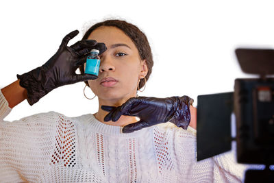 Portrait of young man wearing hat standing against wall