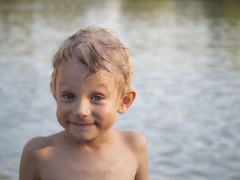 Portrait of shirtless boy at lakeshore