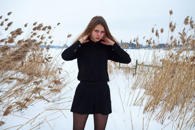 Full length of woman standing on field during winter