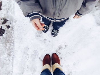 Low section of friends standing on snow