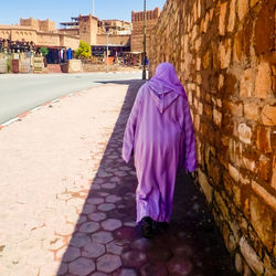 Rear view of people walking on street amidst buildings