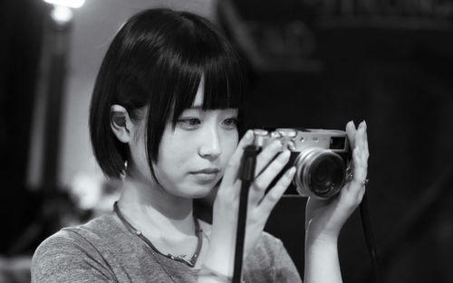 Close-up of young woman photographing through camera