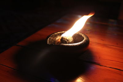 Close-up of burning candle on wooden table