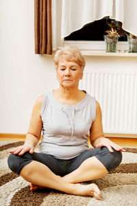 Full length of woman sitting at home