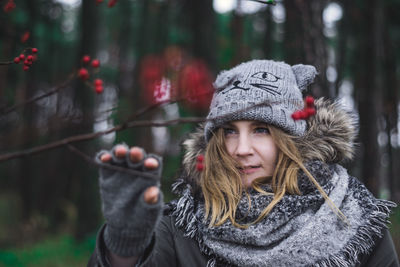 Young woman wearing warm clothing in forest