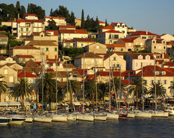 Boats moored in river with buildings in background