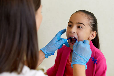 Dentist checking girl's teeth