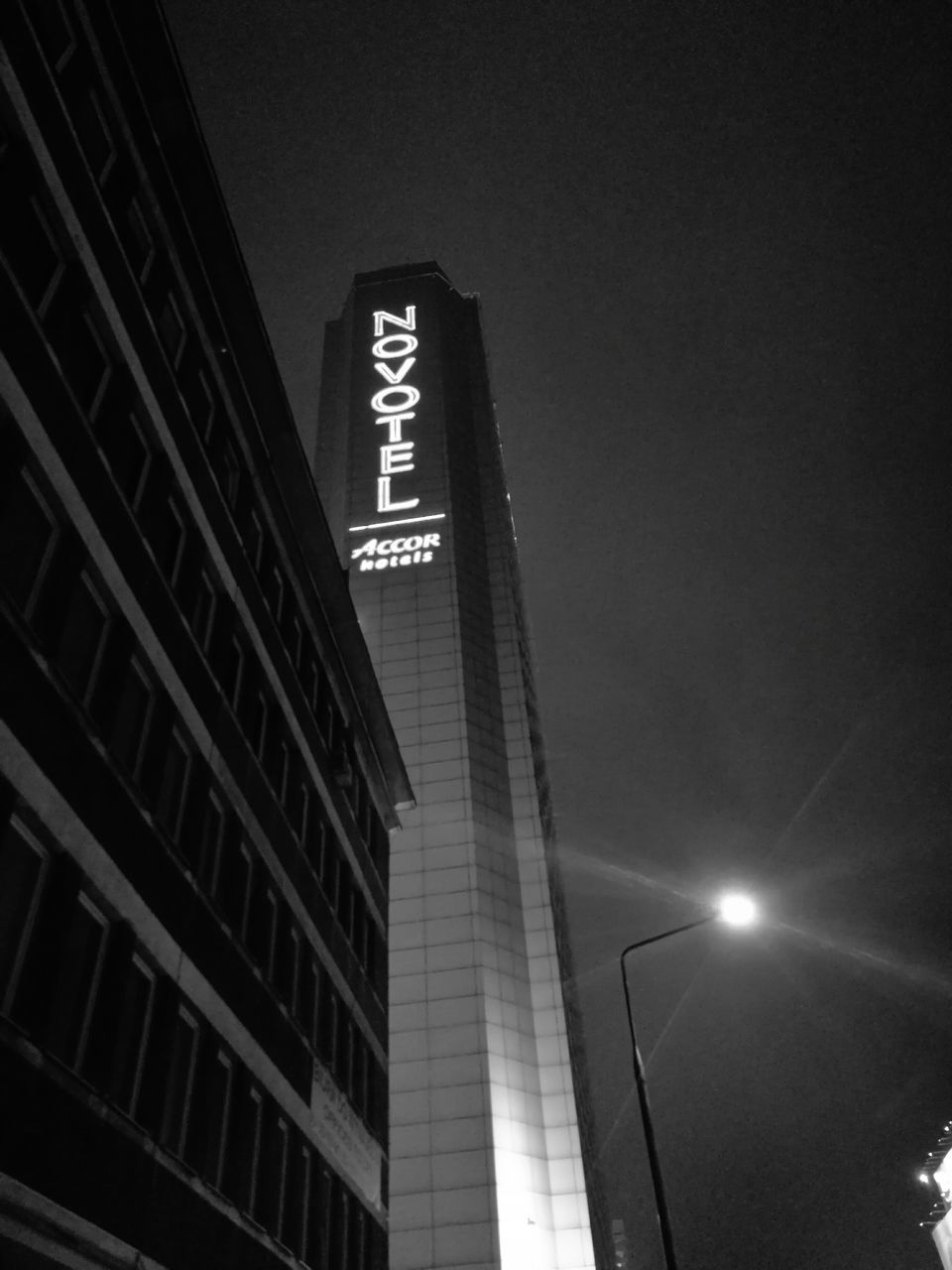 low angle view, architecture, built structure, illuminated, skyscraper, building exterior, text, communication, modern, night, travel destinations, outdoors, city, no people, clear sky, sky