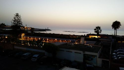 Illuminated city against sky at dusk