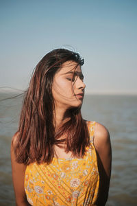 Portrait of young woman against sea