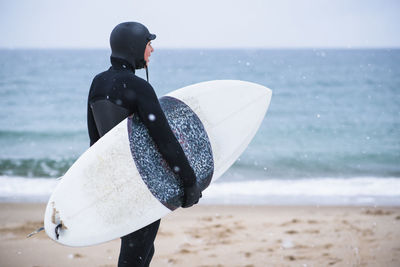 Young woman going winter surfing in snow