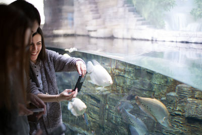 Woman looking at fish in water