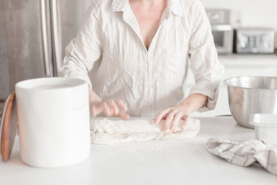 Midsection of woman using mobile phone on table