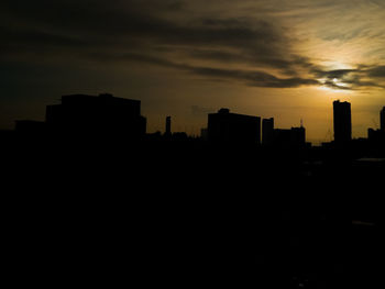 Silhouette buildings against sky during sunset