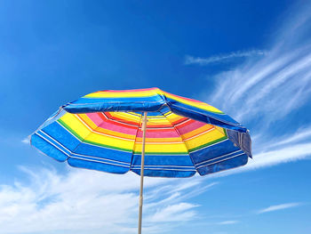 Low angle view of umbrella against blue sky