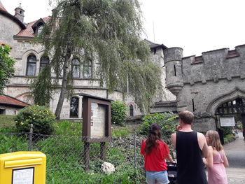 Rear view of people walking by historic building