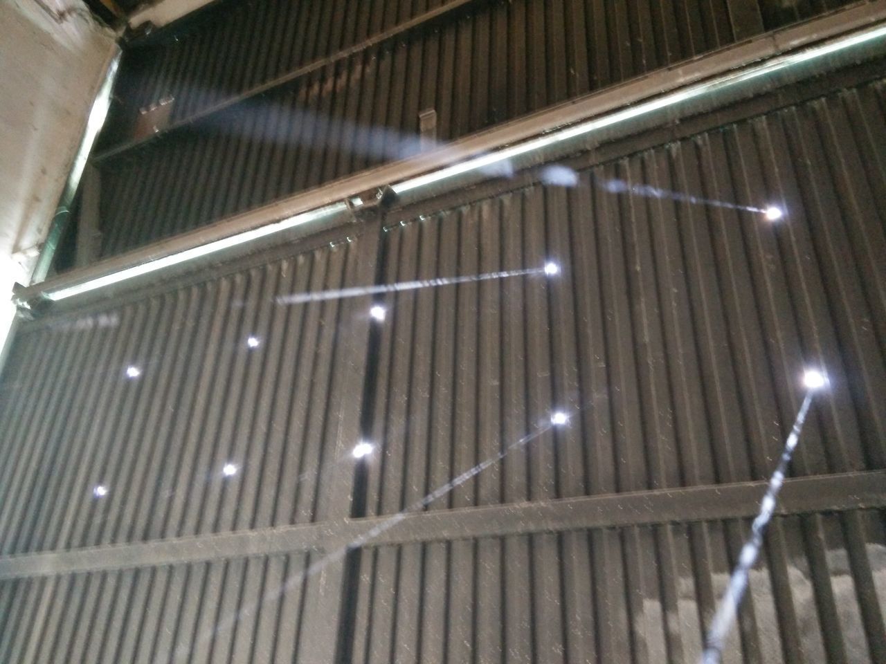 LOW ANGLE VIEW OF ILLUMINATED LIGHTS HANGING IN BUILDING