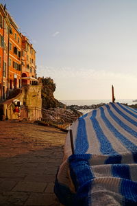 Buildings by sea against sky during sunset