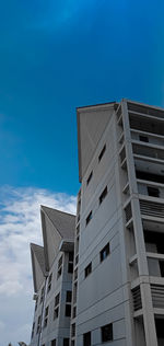 Low angle view of modern building against blue sky