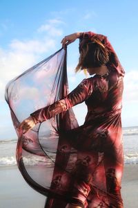 Woman on beach against sky