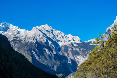 Scenic view of snowcapped mountains against clear blue sky