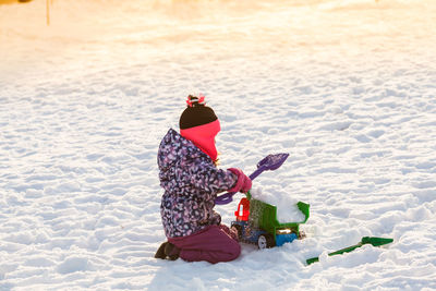 Rear view of girl on field during winter