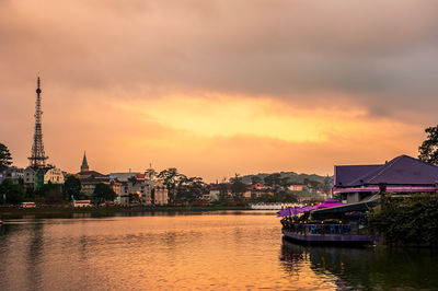 View of buildings at waterfront against cloudy sky