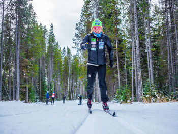 Rear view of man walking in forest during winter