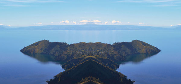 Scenic view of sea by mountains against sky