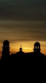 Silhouette of built structure against sky at sunset