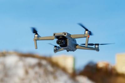 Drone quadcopter in the air against background of the sky