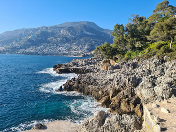 Scenic view of sea and mountains against sky