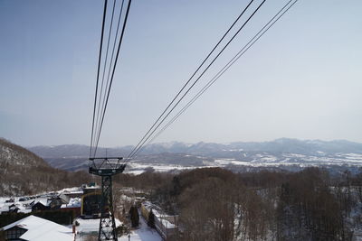 Overhead cable car over snowcapped mountains against sky