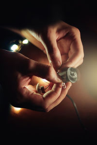 Close-up of hand holding illuminated string lights