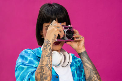 Caucasian girl with short hair tattooed on pink background