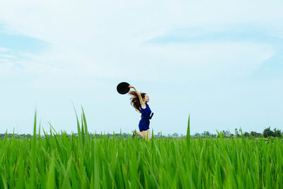 Full length of woman standing on grassy field