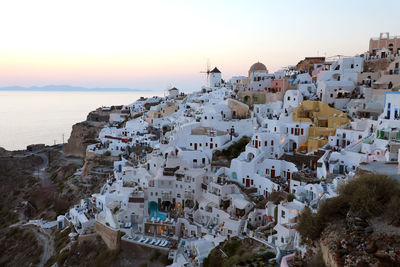 Aerial view of townscape by sea against sky