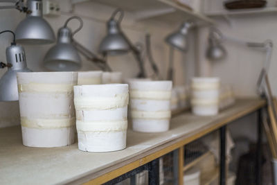 Taped clay vases on workbench at store