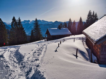 Scenic view of snow covered houses and trees against sky