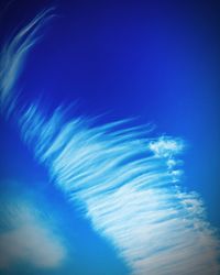 Low angle view of vapor trail in blue sky