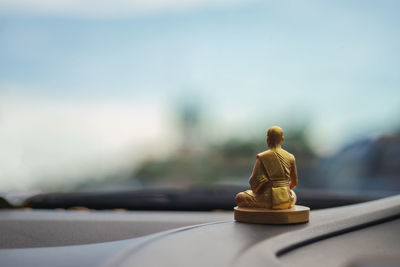 Close-up of figurine on dashboard of car