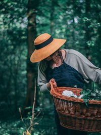 Midsection of man holding hat in basket