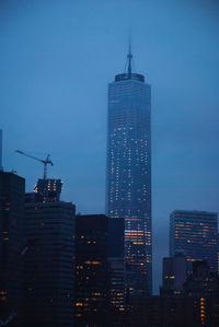 Illuminated buildings in city against sky