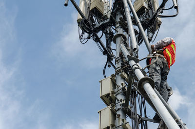 Low angle view of man working against sky