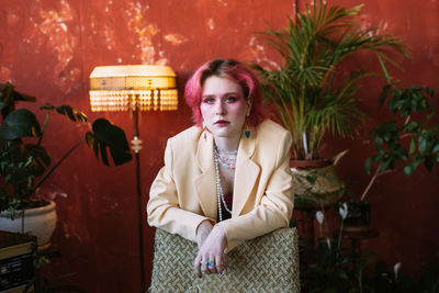 Young woman standing against wall