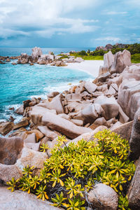 Scenic view of rocks by sea against sky