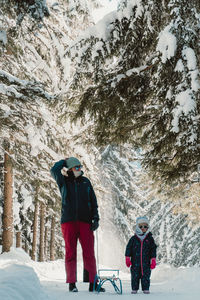 Rear view of man walking on snow covered field