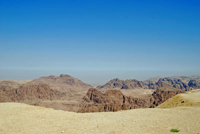 Scenic view of desert against clear blue sky